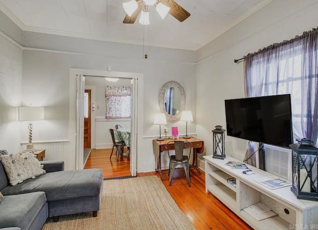 living room featuring light wood-type flooring, crown molding, and ceiling fan