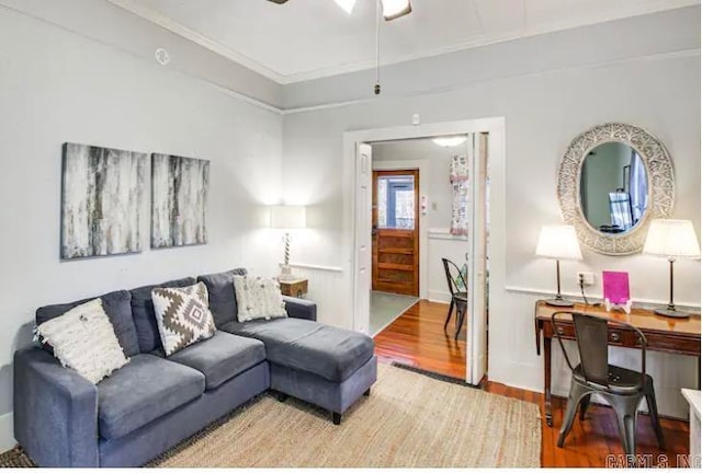 living room featuring crown molding, light hardwood / wood-style flooring, and ceiling fan