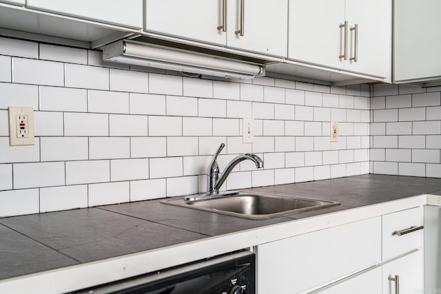 kitchen featuring white cabinetry, backsplash, and sink