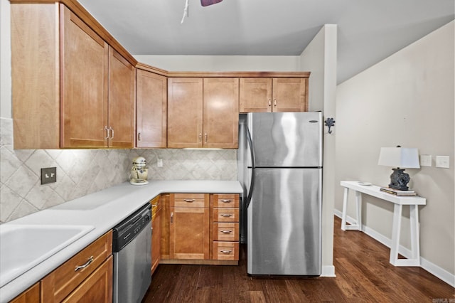 kitchen with appliances with stainless steel finishes, tasteful backsplash, sink, and dark wood-type flooring