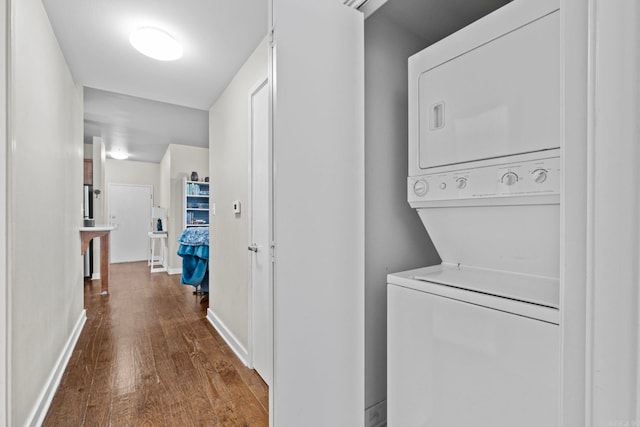 washroom featuring dark hardwood / wood-style flooring and stacked washer / drying machine