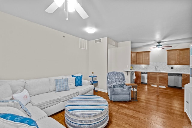 living room with ceiling fan, sink, and hardwood / wood-style floors