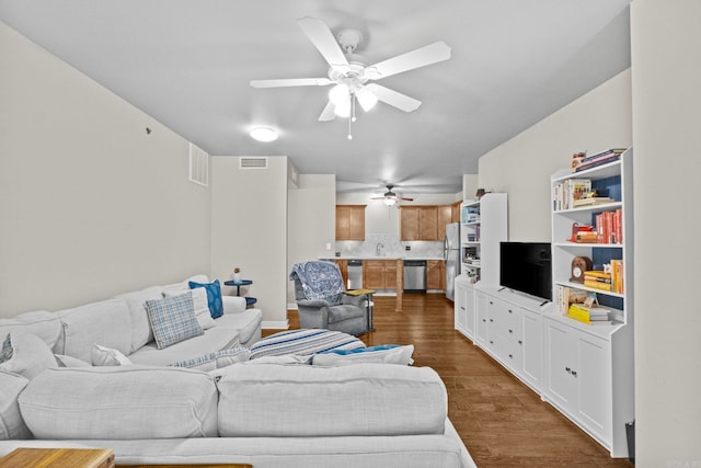 living room featuring ceiling fan, sink, and hardwood / wood-style floors