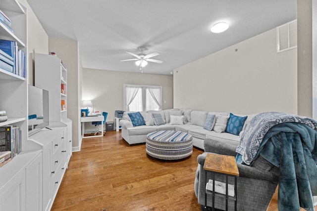 living room featuring light wood-type flooring and ceiling fan