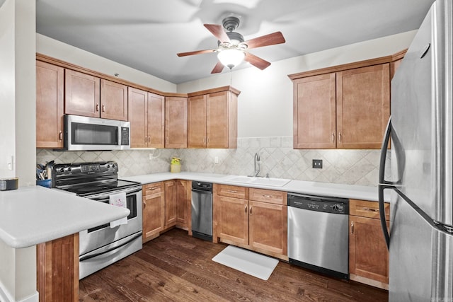 kitchen featuring appliances with stainless steel finishes, sink, dark hardwood / wood-style floors, ceiling fan, and tasteful backsplash