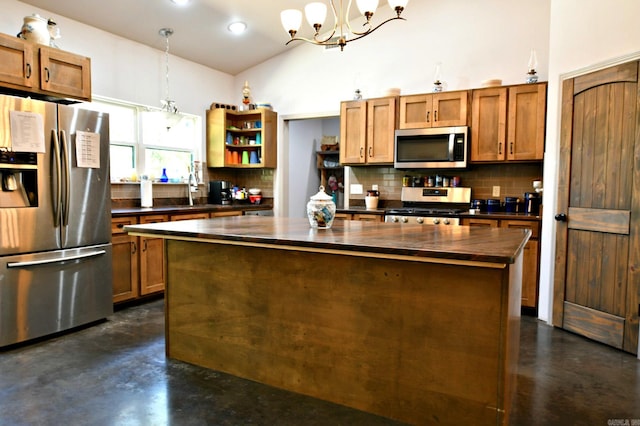 kitchen with a kitchen island, pendant lighting, a notable chandelier, tasteful backsplash, and stainless steel appliances