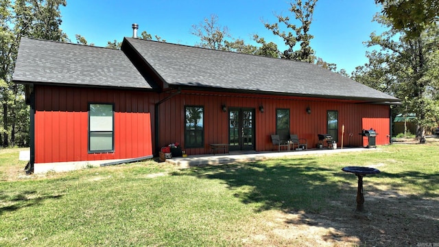 view of front of property with french doors, a front yard, and a patio area