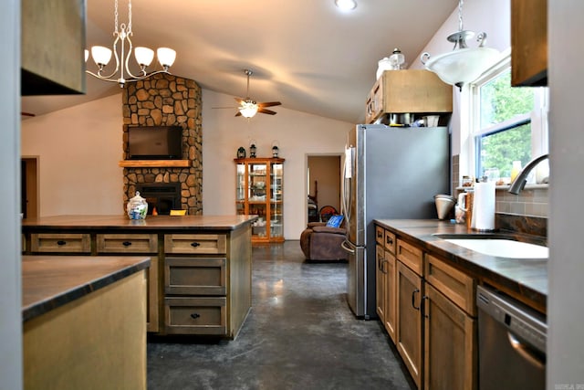 kitchen featuring a fireplace, ceiling fan with notable chandelier, appliances with stainless steel finishes, lofted ceiling, and pendant lighting