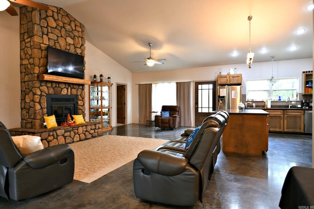 living room with lofted ceiling, sink, ceiling fan, and a stone fireplace