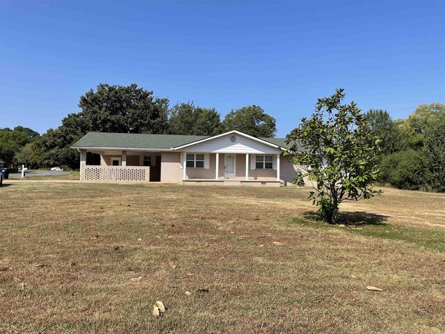 view of front of home with covered porch and a front lawn