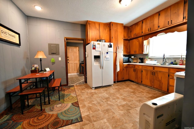 kitchen with a textured ceiling, sink, white fridge with ice dispenser, and electric panel