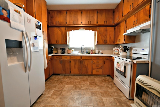 kitchen featuring white appliances, heating unit, and sink