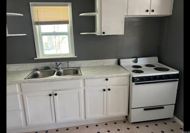 kitchen featuring white range with electric cooktop, white cabinetry, and sink