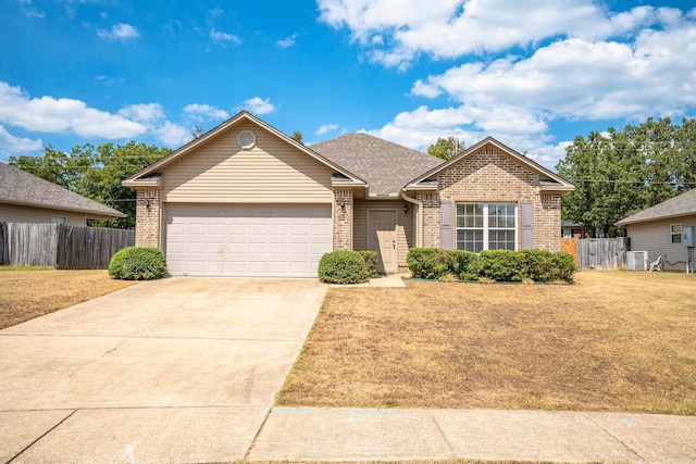 view of front of home featuring a garage, central AC unit, and a front lawn