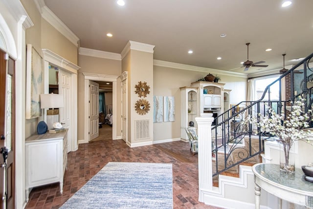 foyer entrance featuring crown molding and ceiling fan