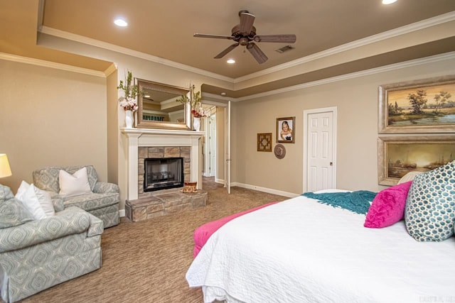 carpeted bedroom featuring a raised ceiling, ceiling fan, ornamental molding, and a stone fireplace