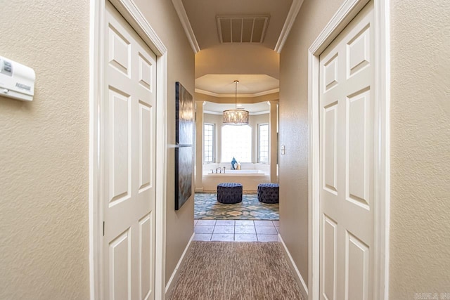 hall with a notable chandelier and ornamental molding