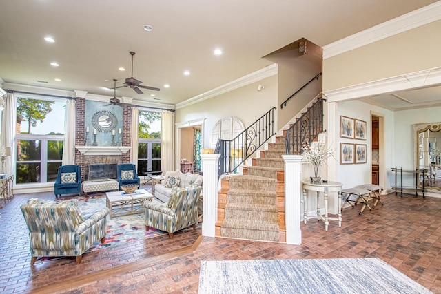 living room featuring ceiling fan, a fireplace, and ornamental molding