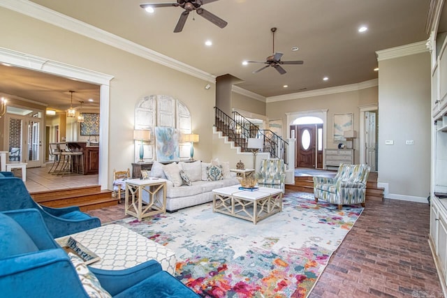 living room featuring ceiling fan with notable chandelier and ornamental molding