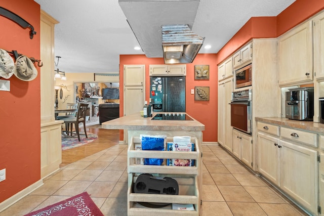 kitchen featuring a textured ceiling, black appliances, and light tile patterned floors