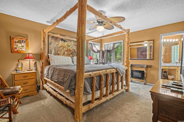 carpeted bedroom featuring a textured ceiling, ceiling fan, and connected bathroom