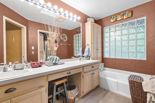 bathroom featuring vanity, a bath, and a textured ceiling