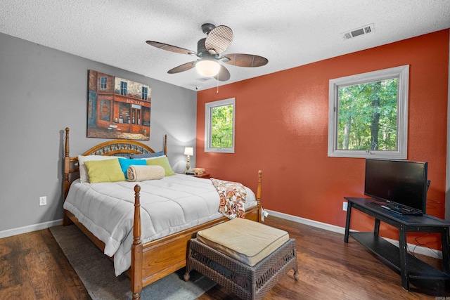 bedroom featuring a textured ceiling, ceiling fan, and dark hardwood / wood-style flooring