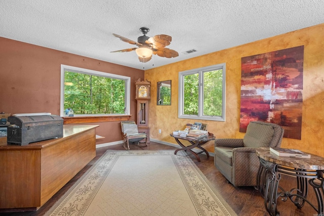 interior space with a textured ceiling, ceiling fan, and hardwood / wood-style floors