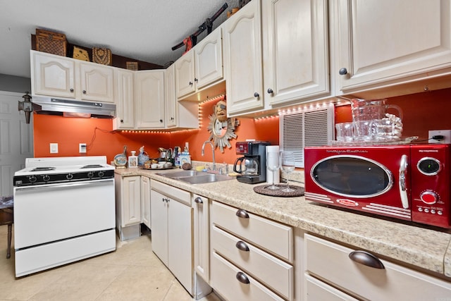 kitchen with white range oven, white cabinetry, sink, light tile patterned flooring, and a textured ceiling