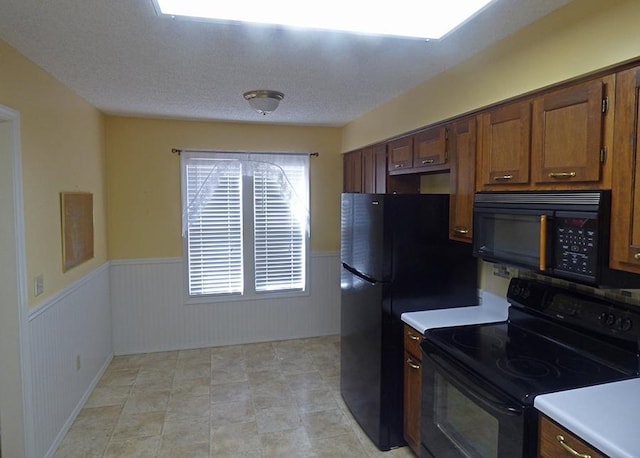 kitchen featuring black appliances and a textured ceiling