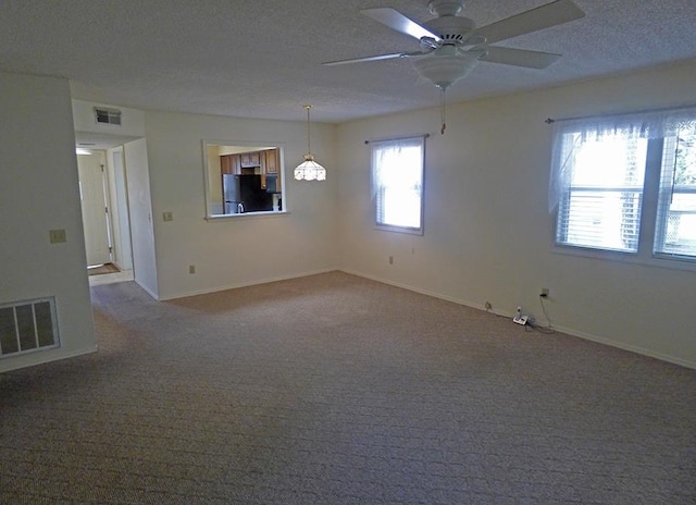 carpeted spare room with ceiling fan and a textured ceiling