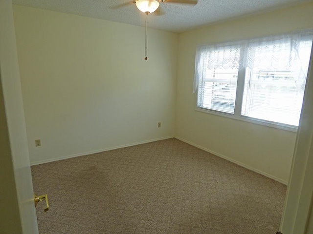 carpeted spare room with a textured ceiling and ceiling fan