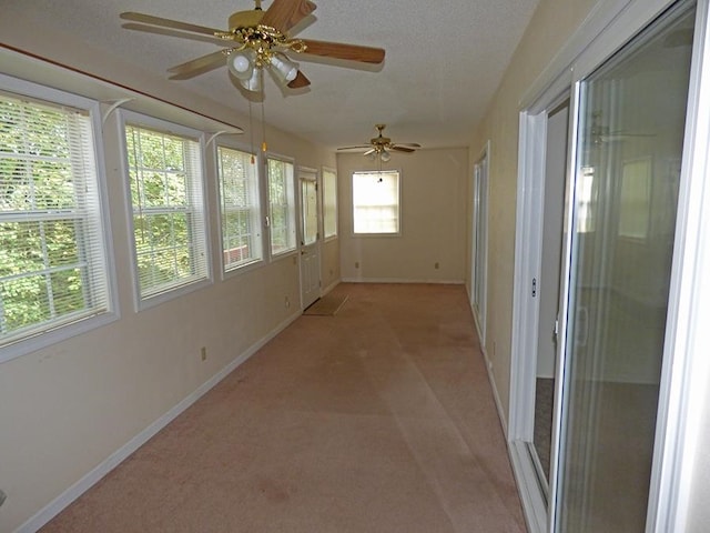 unfurnished sunroom with a healthy amount of sunlight and ceiling fan