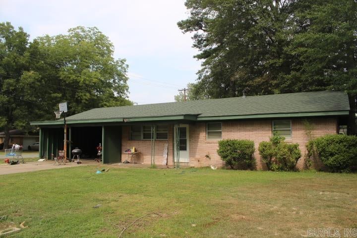 ranch-style home with a carport and a front lawn