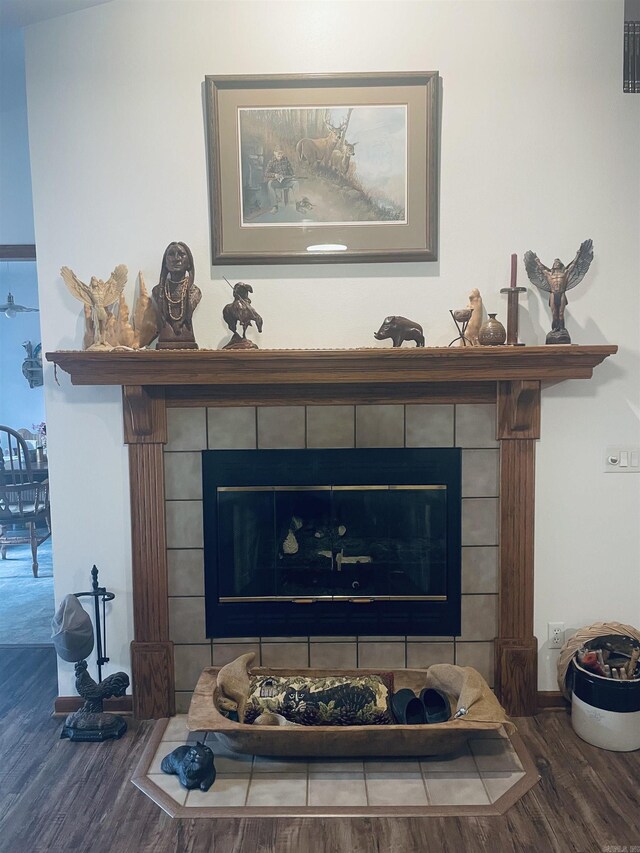 interior details featuring hardwood / wood-style floors and a tiled fireplace