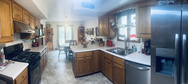 kitchen featuring kitchen peninsula, a wealth of natural light, sink, and appliances with stainless steel finishes