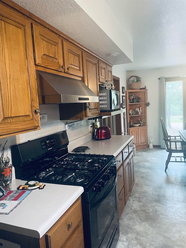 kitchen featuring black range with gas stovetop and a textured ceiling