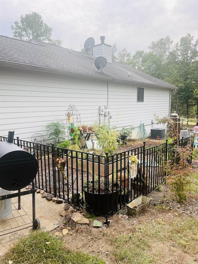 exterior space featuring central air condition unit and roof with shingles