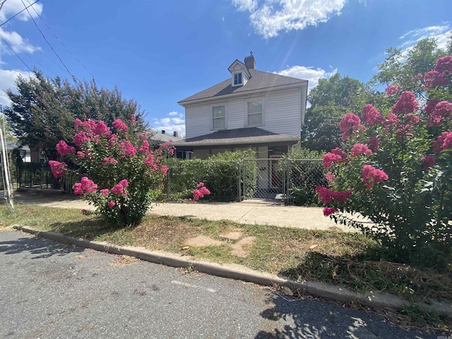 view of front of home with a fenced front yard and a gate