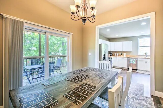 dining area with dark hardwood / wood-style flooring, an inviting chandelier, and sink