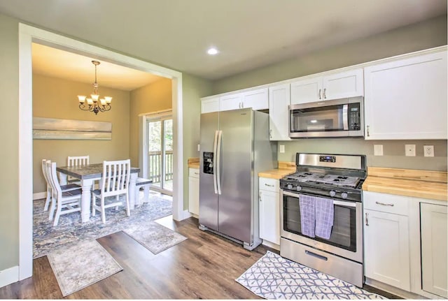 kitchen with white cabinets, butcher block countertops, and stainless steel appliances