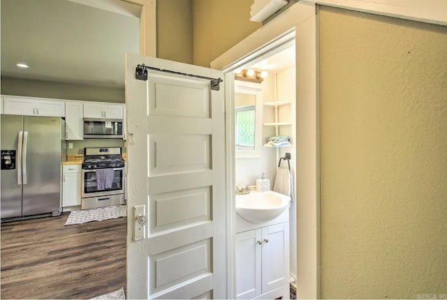 bathroom with vanity, wood finished floors, and a textured wall