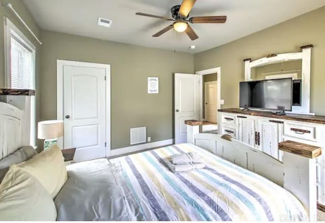 bedroom featuring a ceiling fan, baseboards, and visible vents