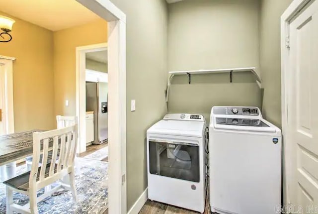 laundry area with wood finished floors, washing machine and dryer, and laundry area