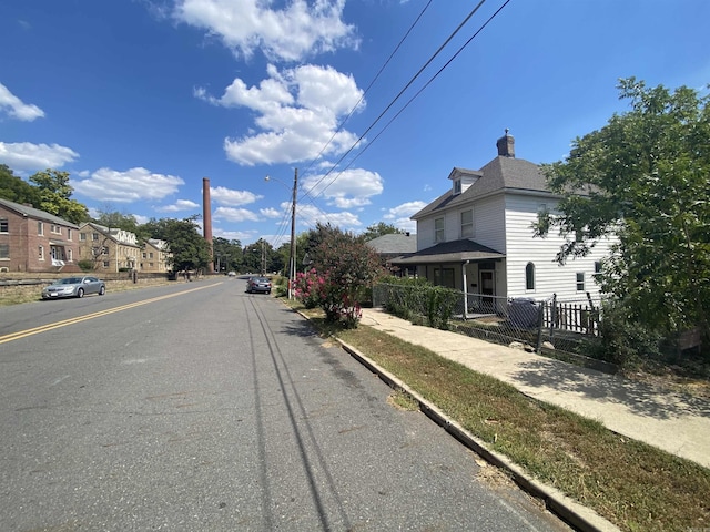 view of road featuring curbs, street lights, and sidewalks