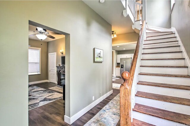 stairway with ceiling fan and hardwood / wood-style flooring