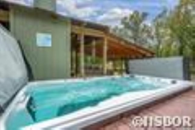 view of swimming pool with a covered hot tub