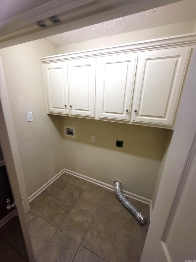 laundry area with hookup for a washing machine, cabinets, electric dryer hookup, and dark tile patterned flooring