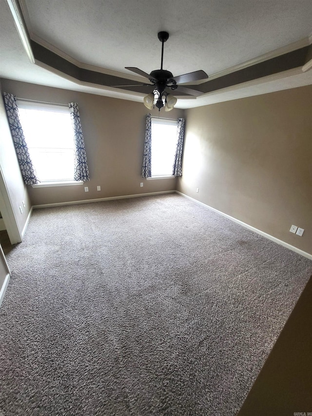 spare room featuring a tray ceiling, a textured ceiling, ceiling fan, and carpet flooring