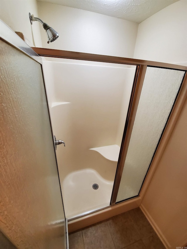 bathroom featuring an enclosed shower and tile patterned floors